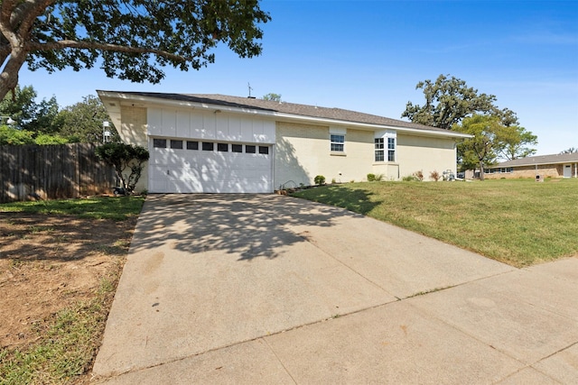 exterior space with driveway, board and batten siding, an attached garage, fence, and a yard