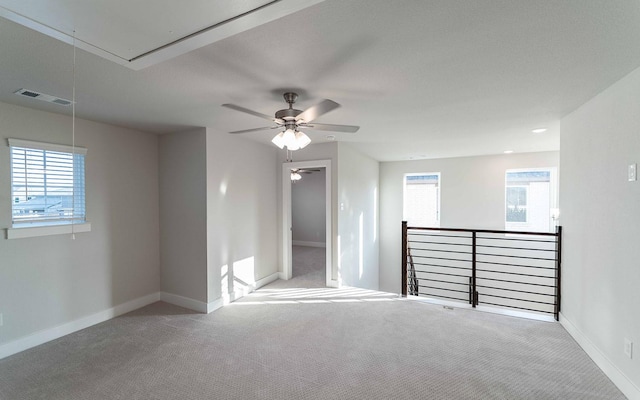 carpeted spare room featuring ceiling fan