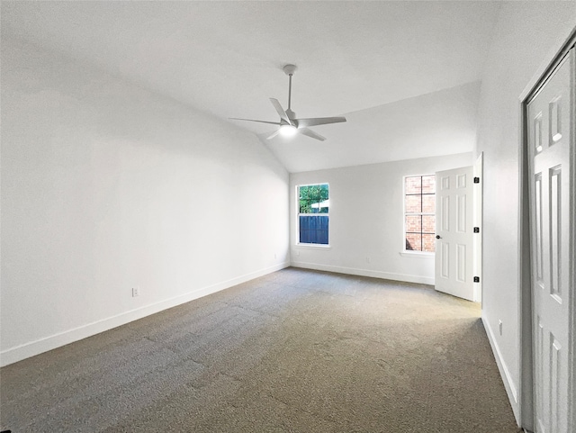 empty room featuring ceiling fan, lofted ceiling, and carpet flooring