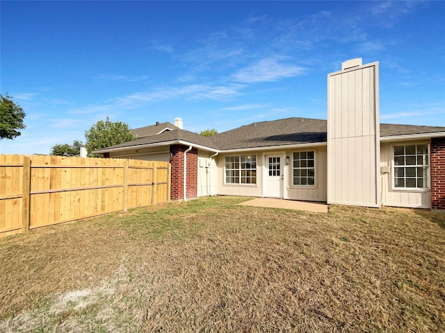 rear view of property with a lawn