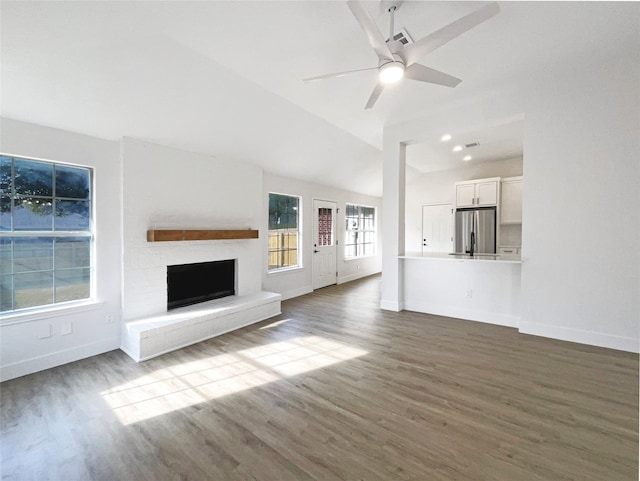 unfurnished living room with lofted ceiling, ceiling fan, and dark hardwood / wood-style flooring