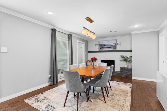 dining space with wood-type flooring, a brick fireplace, and ornamental molding