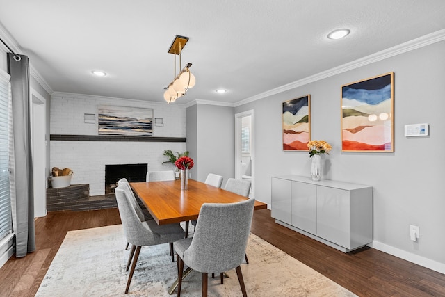 dining room with a textured ceiling, a fireplace, ornamental molding, and dark hardwood / wood-style floors