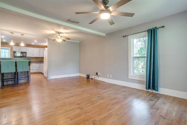 living room with beam ceiling, ceiling fan, and light hardwood / wood-style flooring