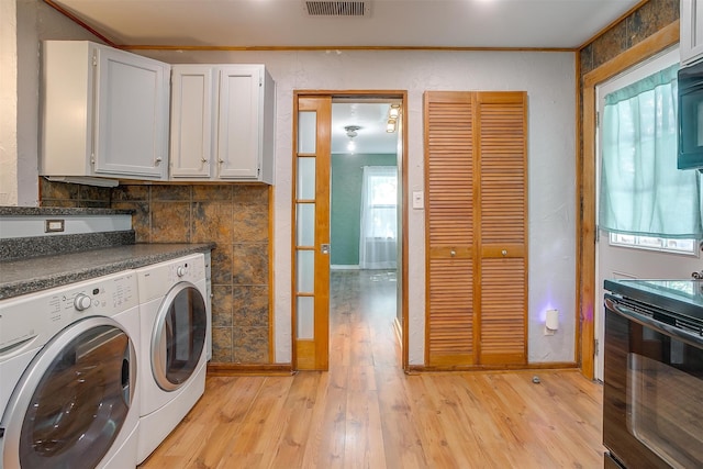 laundry room with washing machine and clothes dryer, light hardwood / wood-style floors, and ornamental molding