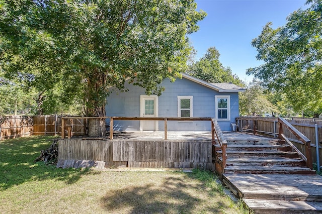 rear view of property featuring a lawn and a wooden deck