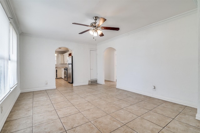 spare room with ceiling fan, light tile patterned floors, and crown molding