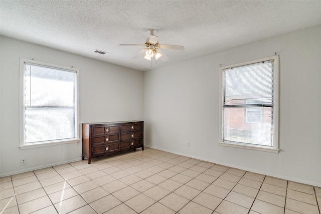 unfurnished room featuring plenty of natural light, ceiling fan, and light tile patterned flooring