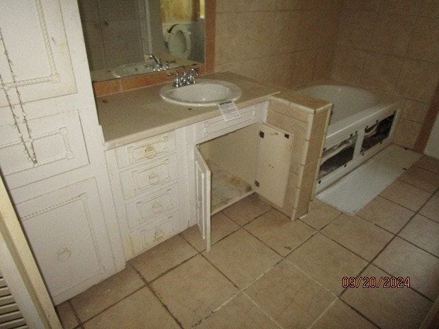 bathroom with tile patterned flooring, a washtub, and vanity