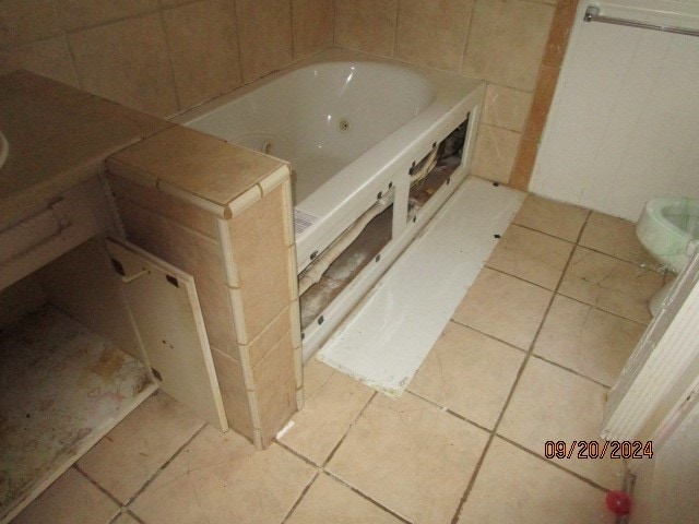 bathroom with tile patterned flooring and a bath