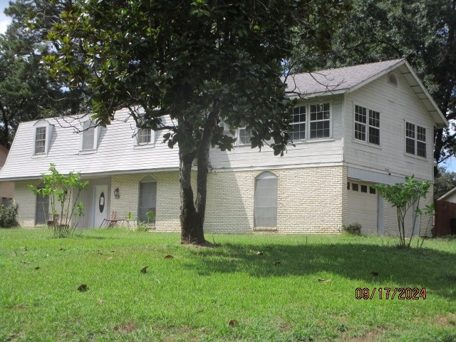 view of front of property with a garage and a front lawn