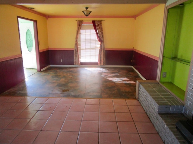 interior space with a wainscoted wall, wood walls, and visible vents