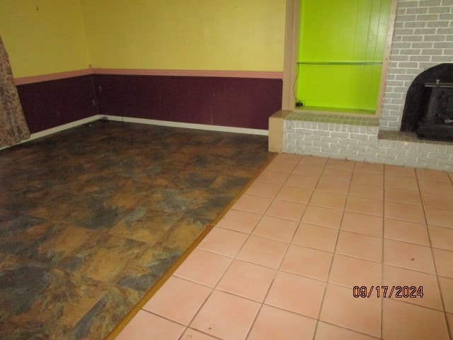 interior space featuring tile patterned flooring and a brick fireplace