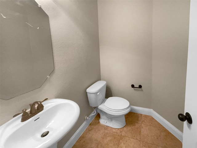 bathroom featuring toilet, sink, and tile patterned floors