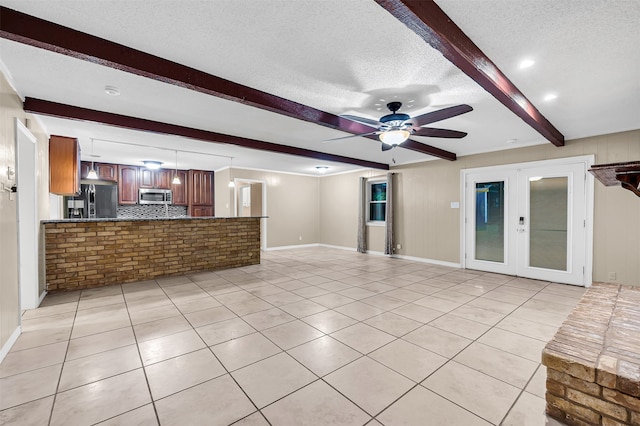 unfurnished living room featuring beam ceiling, french doors, light tile patterned flooring, and a textured ceiling