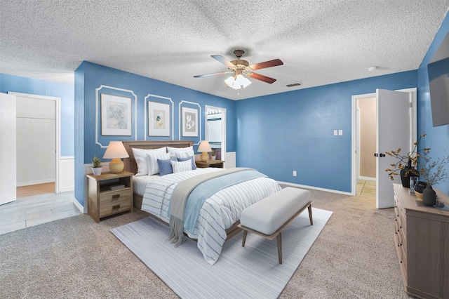 carpeted bedroom with a textured ceiling and ceiling fan