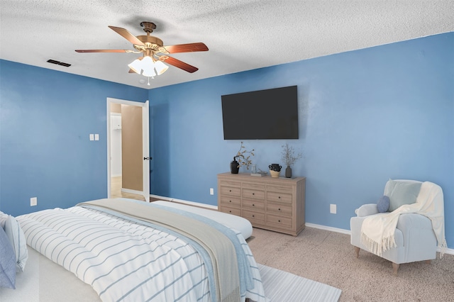 carpeted bedroom featuring a textured ceiling and ceiling fan