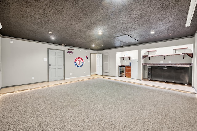 interior space with light colored carpet, ornamental molding, a textured ceiling, and wine cooler