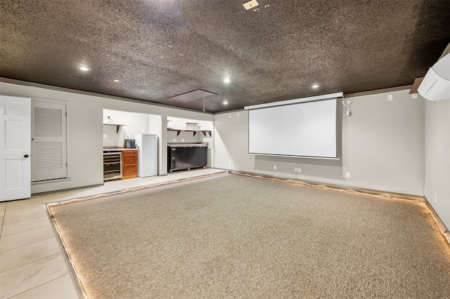 home theater room featuring crown molding, wine cooler, light tile patterned floors, a textured ceiling, and a wall unit AC