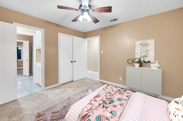 bedroom featuring a textured ceiling, ceiling fan, and light carpet