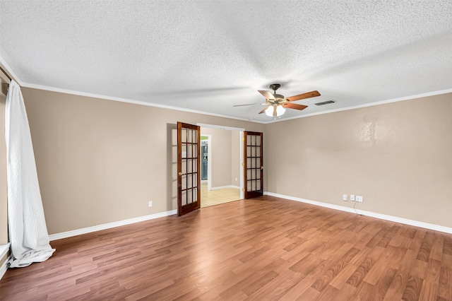 spare room with french doors, crown molding, hardwood / wood-style floors, and a textured ceiling