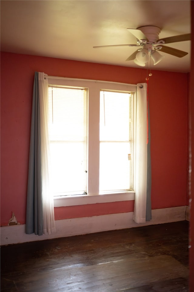 empty room with ceiling fan and dark hardwood / wood-style flooring