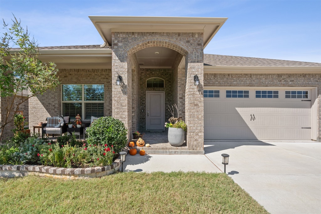 doorway to property with a lawn and a garage