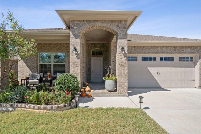 doorway to property with a lawn and a garage