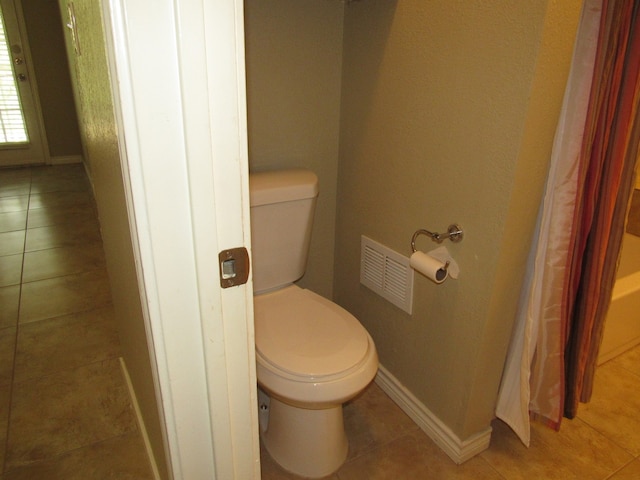 bathroom with toilet and tile patterned floors