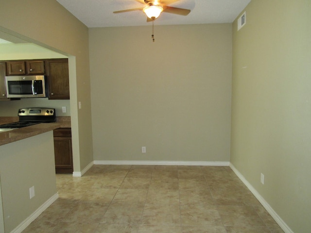 kitchen featuring ceiling fan, light tile patterned flooring, appliances with stainless steel finishes, and dark brown cabinets