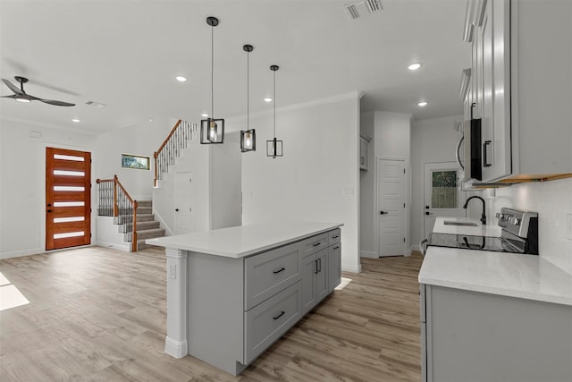 kitchen with light wood-type flooring, gray cabinetry, and a center island