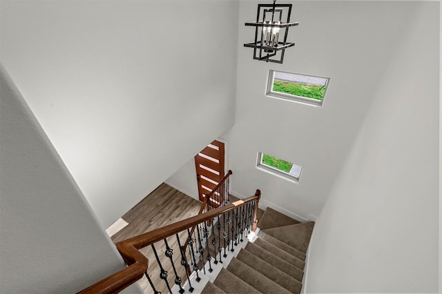 stairs with an inviting chandelier and hardwood / wood-style flooring