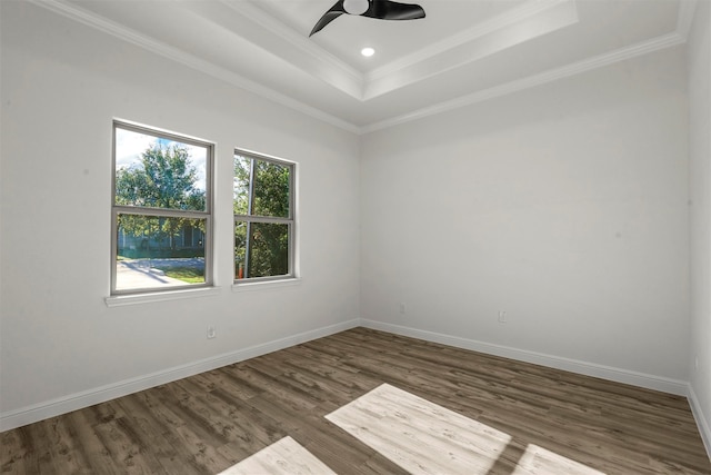 empty room featuring ornamental molding, a raised ceiling, and dark hardwood / wood-style flooring