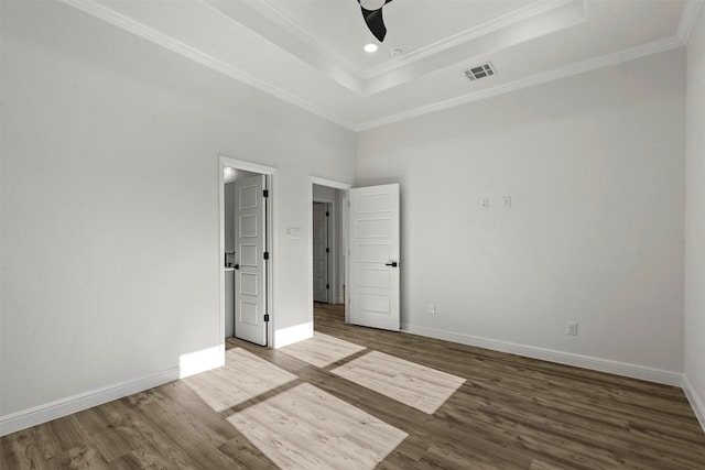 unfurnished bedroom featuring wood-type flooring, a tray ceiling, ceiling fan, and crown molding