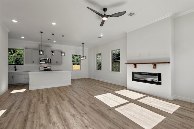 unfurnished living room with ceiling fan, light hardwood / wood-style flooring, and crown molding