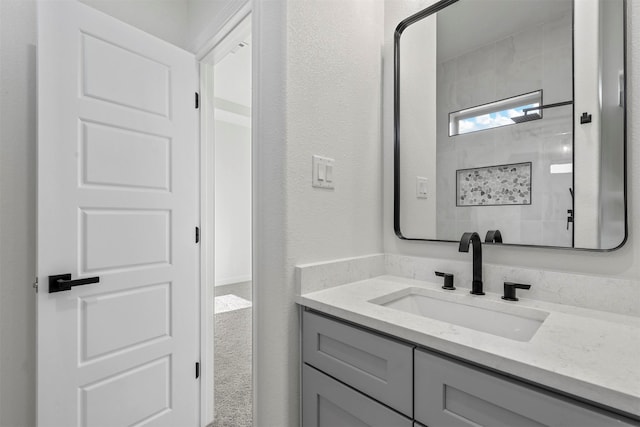 bathroom with walk in shower and vanity