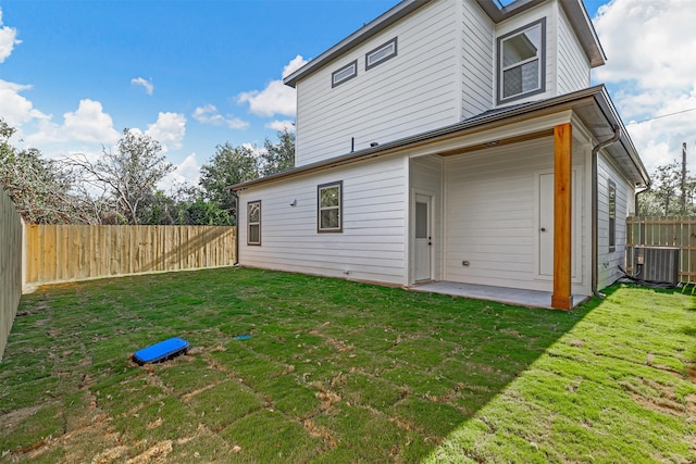 rear view of property with a lawn and central AC unit