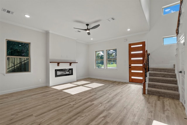 unfurnished living room with light wood-type flooring, crown molding, and ceiling fan