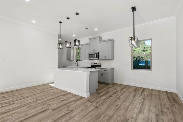 kitchen featuring appliances with stainless steel finishes, light hardwood / wood-style floors, pendant lighting, and gray cabinets