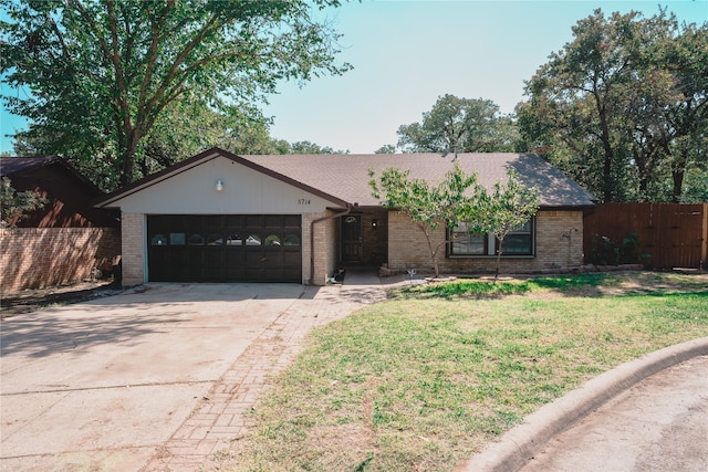 ranch-style home featuring a garage and a front lawn