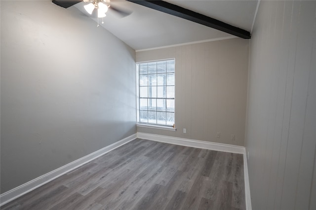 empty room featuring wooden walls, ceiling fan, hardwood / wood-style floors, and crown molding