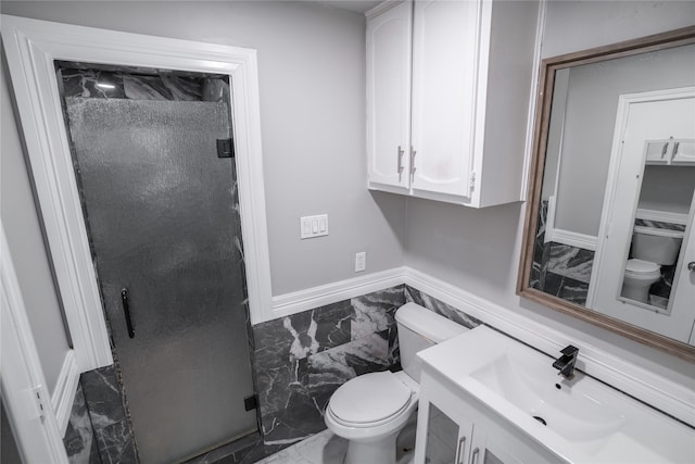 bathroom featuring vanity, toilet, and a shower with shower door