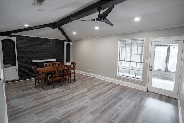 dining area featuring ceiling fan, vaulted ceiling with beams, brick wall, and light hardwood / wood-style floors