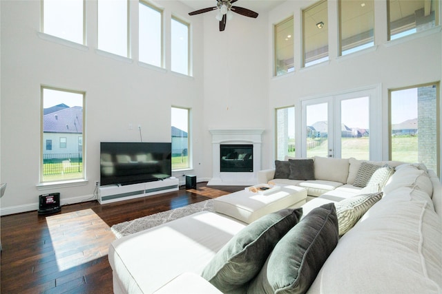 living room featuring a wealth of natural light, ceiling fan, and dark hardwood / wood-style floors