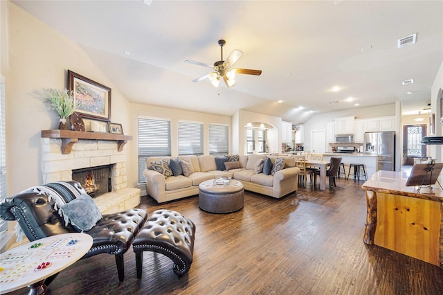 living room featuring a stone fireplace, ceiling fan, dark hardwood / wood-style flooring, and lofted ceiling