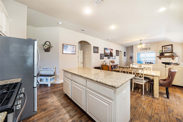 kitchen with white cabinets, ceiling fan, a center island, and dark hardwood / wood-style flooring