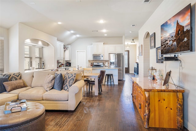 living room with dark hardwood / wood-style flooring and lofted ceiling