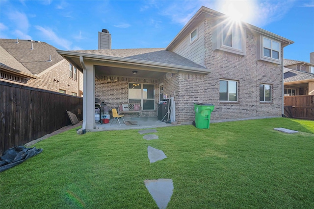 back of property featuring a patio area and a lawn