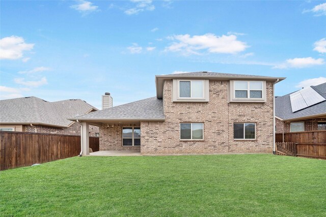 rear view of property with a lawn and a patio area