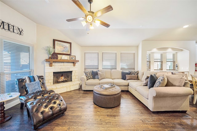 living room with a fireplace, dark hardwood / wood-style floors, vaulted ceiling, and ceiling fan